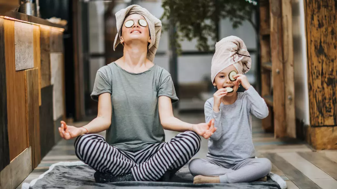 Mother doing yoga with daughter at home