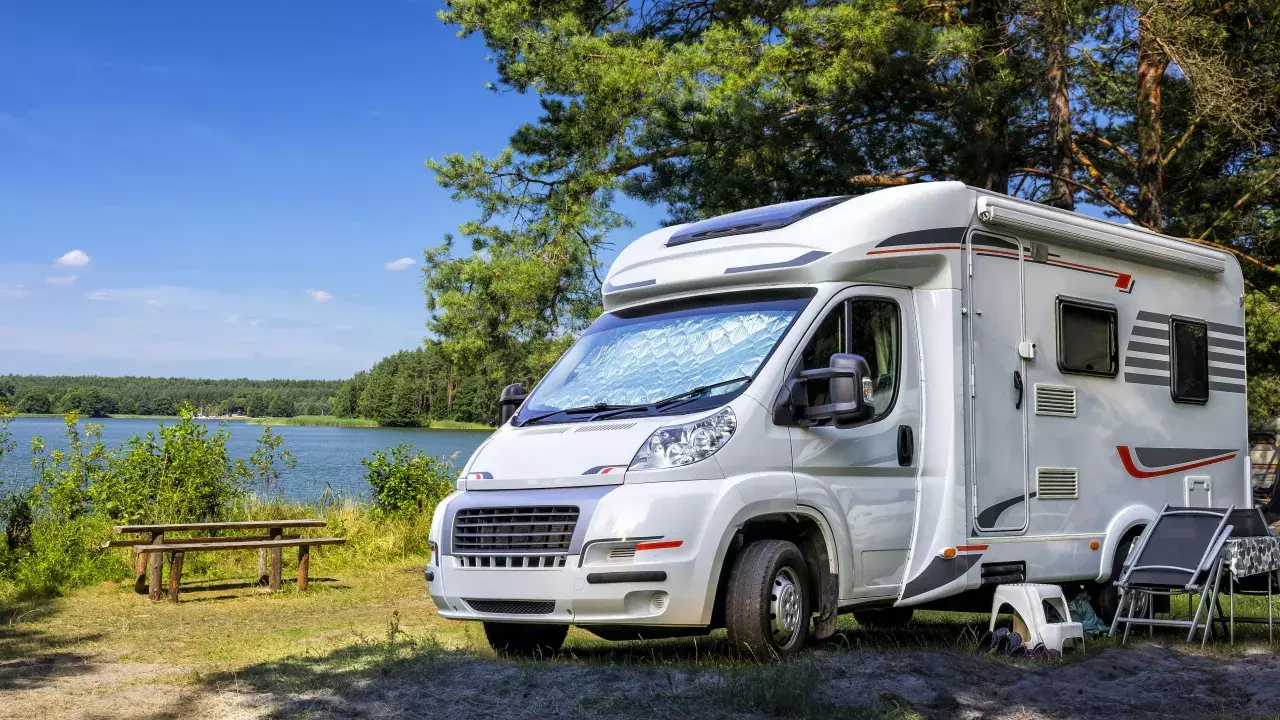 RV parked beside a picnic table and water