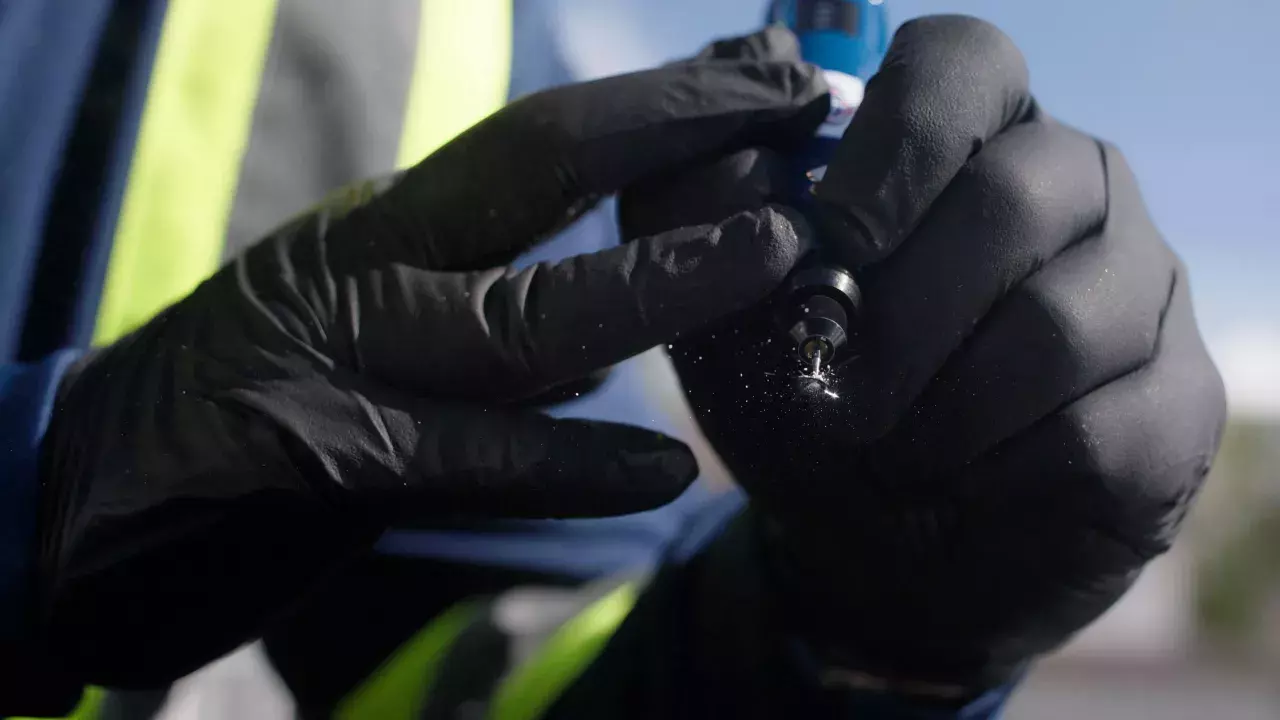 technician fixing a chip repair in windshield