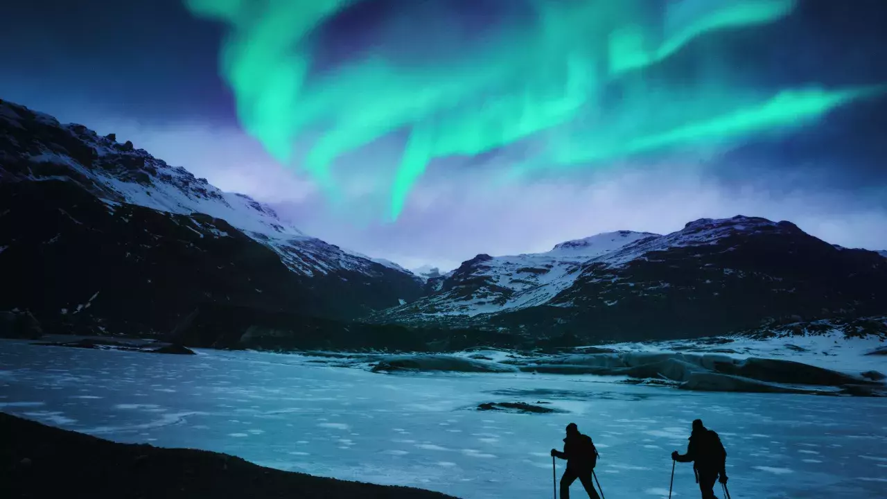 Two hikers in Iceland with the northern lights