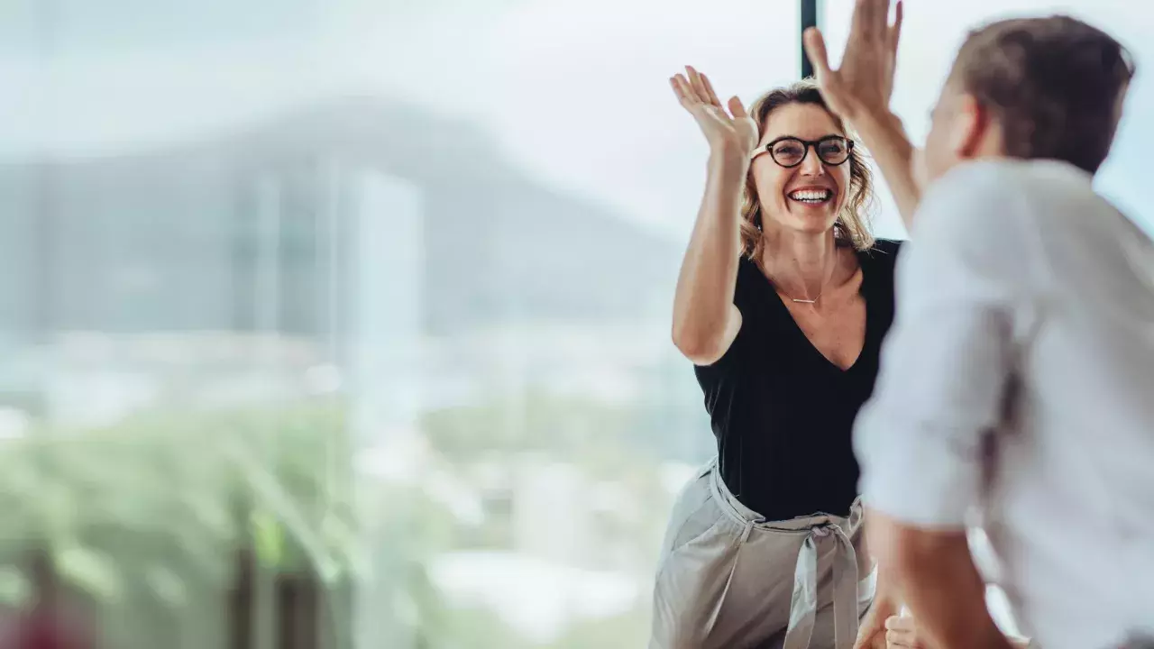 Businesswoman giving a high five to a colleague in meeting 