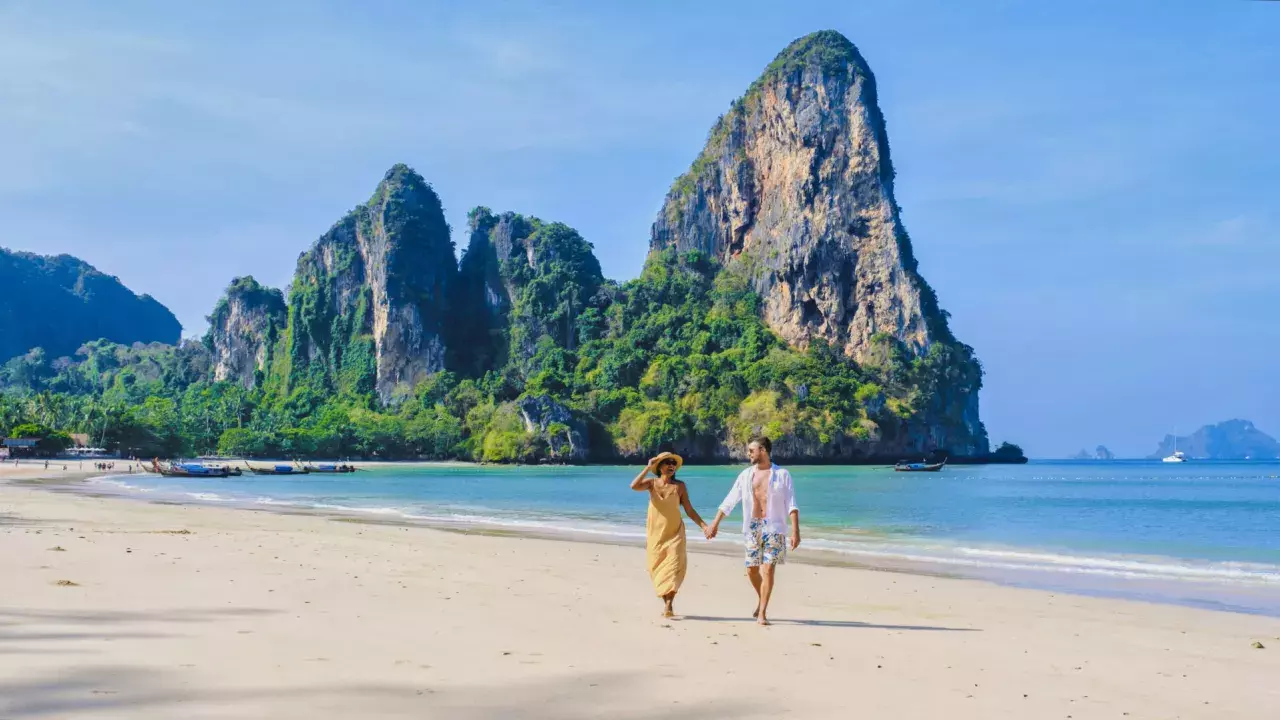 couple of men and woman relaxing on the beach during vacation in Thailand Railay Beach Krabi