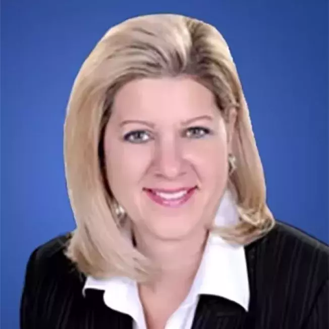 Professional image of a women smiling at a camera infront of a blue backdrop