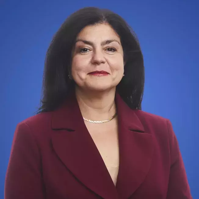 Professional image of a woman infront of a blue backdrop