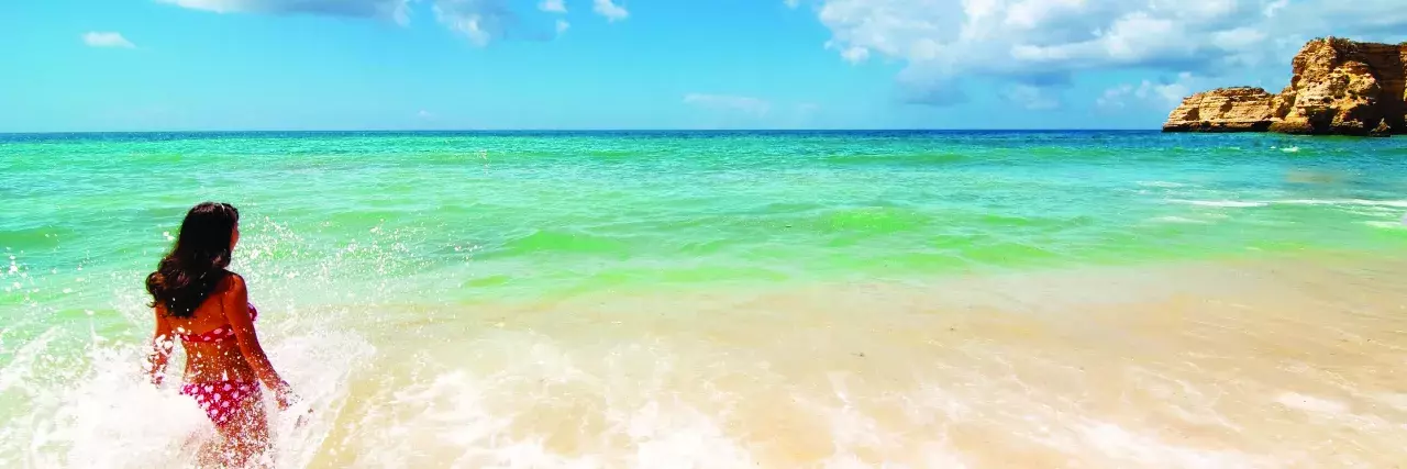 Woman wading out into the ocean