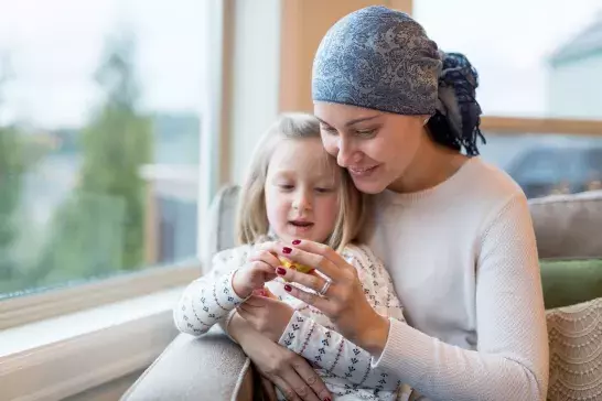 Mother with a critical illness sitting in front of a window with daughter