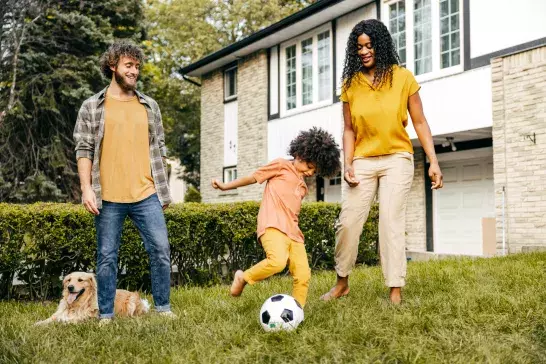 Couple and their daughter spending quality time together outside on their lawn.