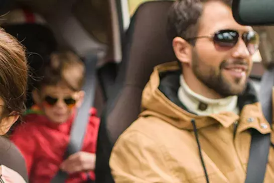 a picture of a family driving in a car