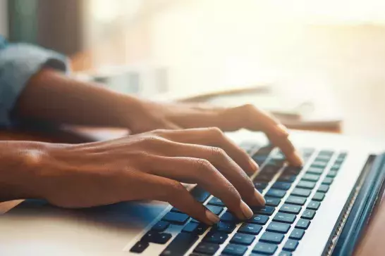 A woman typing on a laptop