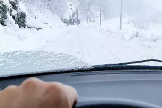 Driving a car on a road full of snow