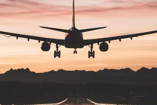 Airplane landing in sunset