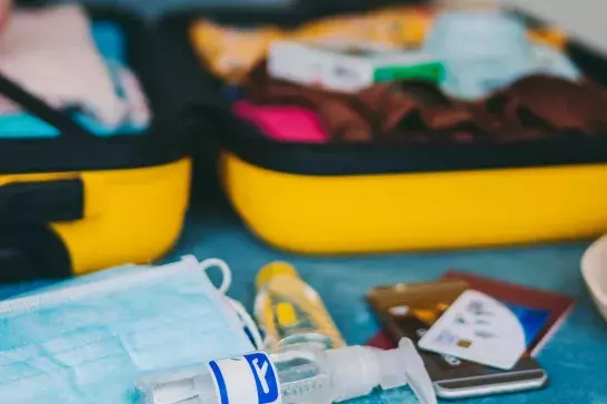 Packing luggage with face mask and hand sanitizer 