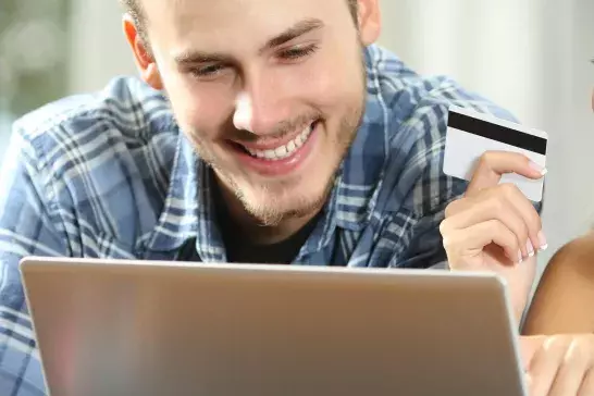 Couple using laptop holding a membership card