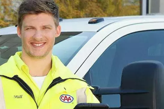 Smiling CAA employee in front of a CAA truck