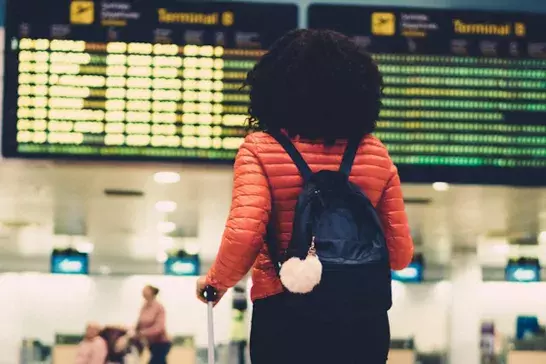 Woman standing at the airport with her luggage