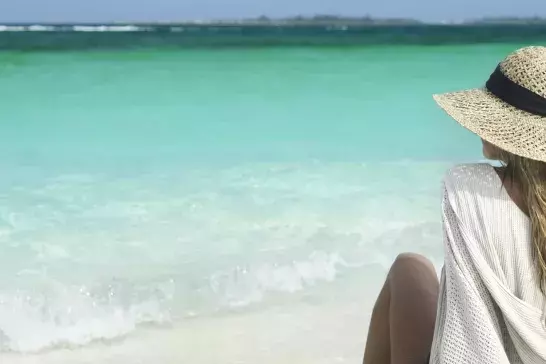 Woman sitting on beach in Bahamas