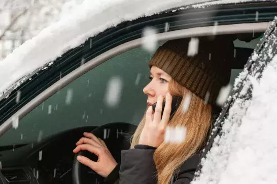 Woman calling for help in a snow covered car