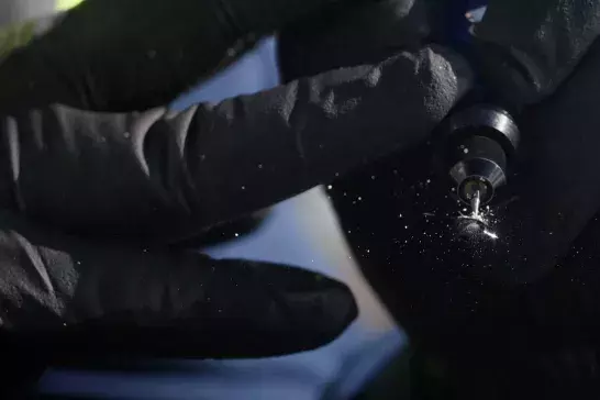 Hands against a windshield completing a chip repair.