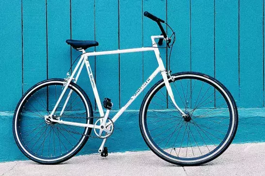 A sports bike leaned up against a turquoise wall.