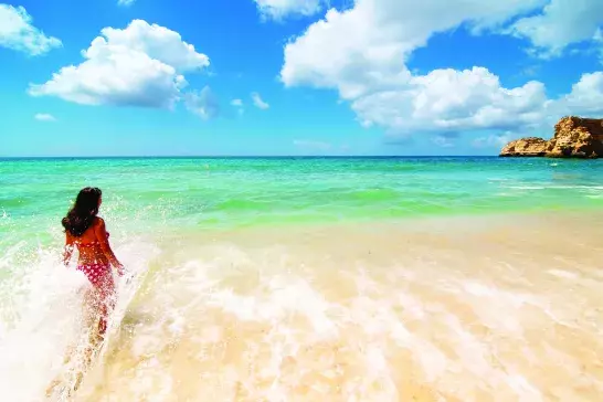 Woman wading out into the ocean