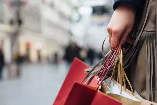 A hand holding shopping bags