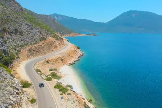 Grey car driving along the beautiful shoreline of a scenic remote island