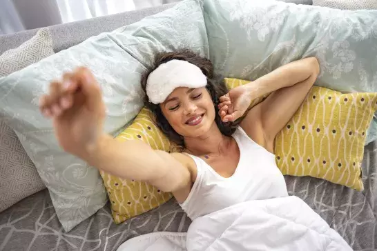 Close up of a woman stretching on a bed.