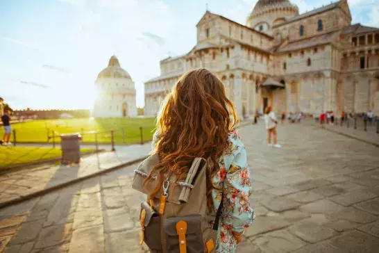 Seen from behind stylish woman in floral dress having excursion