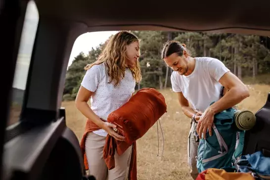 Young couple preparing gear for hike