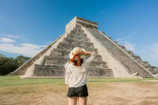 Woman on the background of Chichen Itza pyramid in Mexico