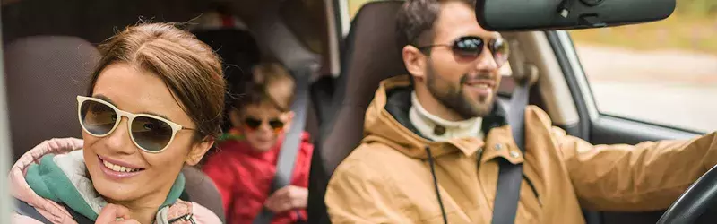 a picture of a family driving in a car