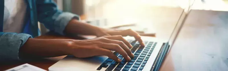 A woman typing on a laptop