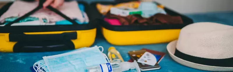 Packing luggage with face mask and hand sanitizer 