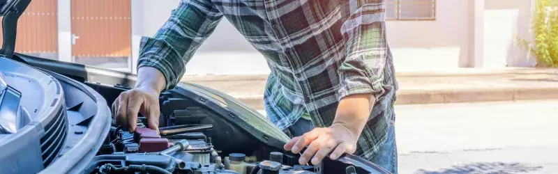 man checking oil in car