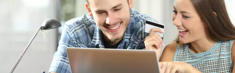 Couple using laptop holding a membership card