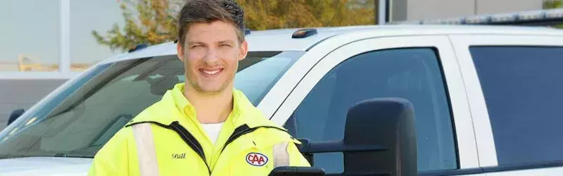 Smiling CAA employee in front of a CAA truck