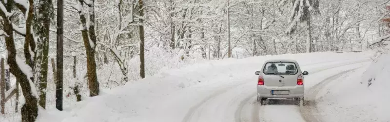 car driving on a winter road in forest