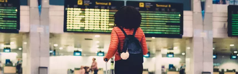 Woman standing at the airport with her luggage