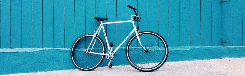 A sports bike leaned up against a turquoise wall.