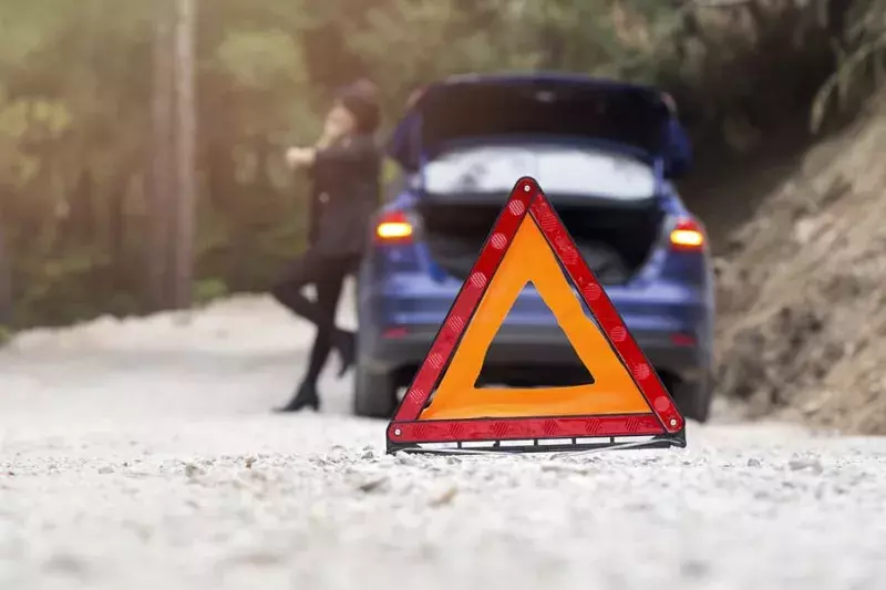 woman having car trouble. triangle sign. 