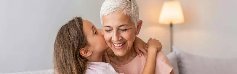 Grandmother and granddaughter hugging.