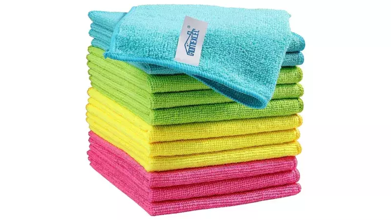 A neatly stacked pile of microfiber cleaning cloths in various colors, including blue, green, yellow, and pink. A separate blue cloth is folded and placed on top of the stack, featuring a white label.