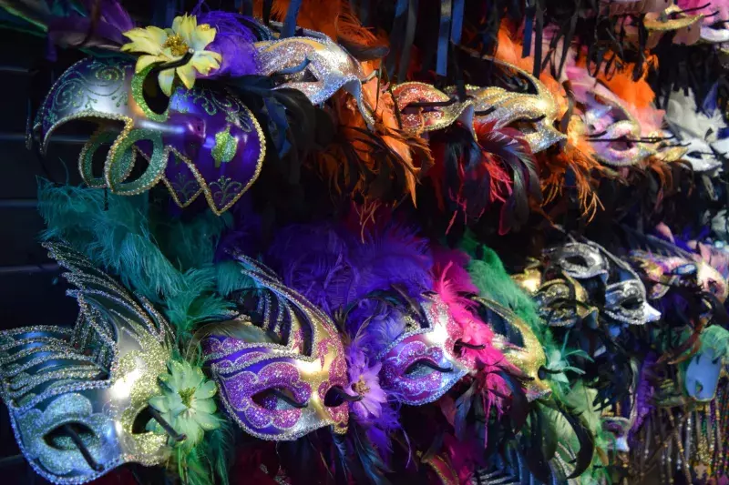 Colorful Mardi Gras carnival masks hanging on shelf.