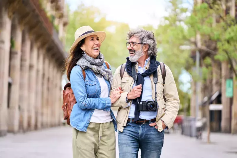 Happy older couple having fun walking outdoors in city. Retired people enjoying a sightseeing walk.