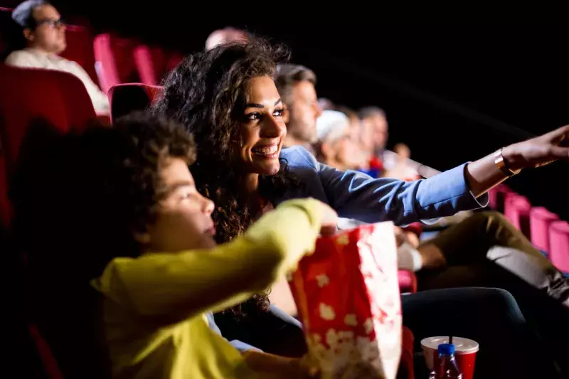 Happy woman enjoying with her son at the cinema