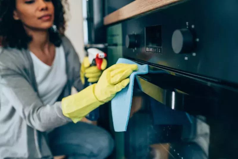 Woman wiping surface at home.