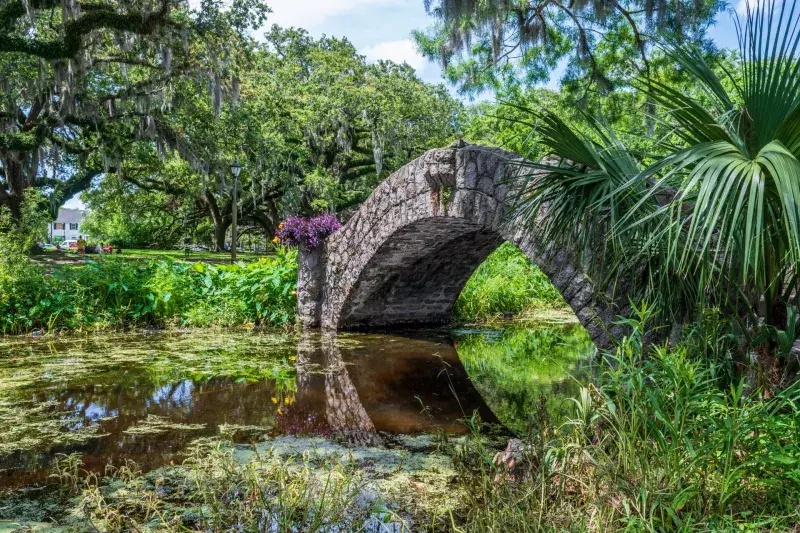 New Orleans, Louisiana - May 23, 2021: Langles Bridge in New Orleans City Park is one of three stone foot bridges in the park built in 1902.