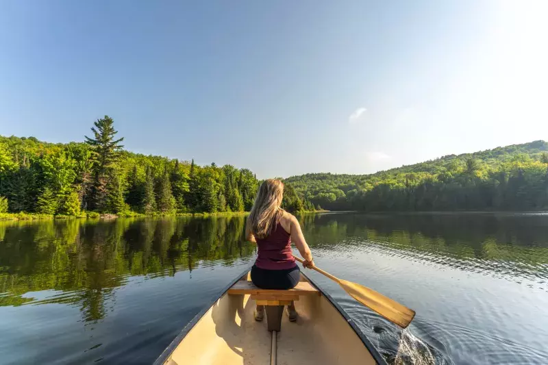 A woman canoeing in early morning.