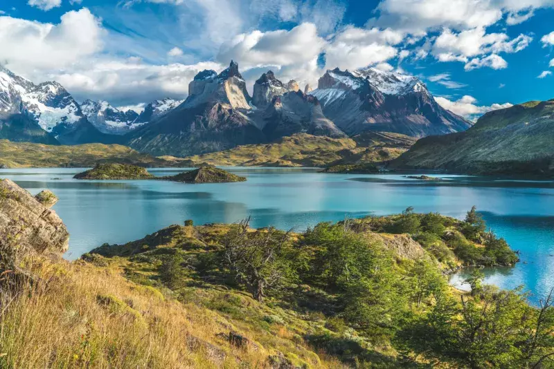 Blue lake on a snowy mountains background and cloudy sky Torres del paine